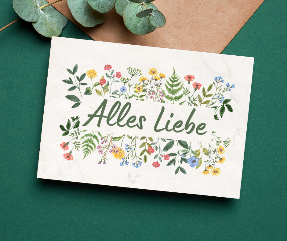 Postkarte mit dem Text "Alles Liebe". Die Karte besteht aus Samenpapier. Bunte Blumen säumen den Rand des Textes.