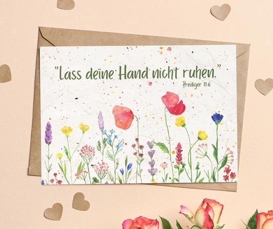 Bunte Blumen am unteren Rand und grüner Text "Lass deine Hand nicht ruhen."